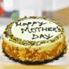 Golden Love Mom Cake – beautifully decorated butterscotch cake with “Mom” written on top, golden caramel drizzle, and floral frosting accents, perfect for Mother’s Day.