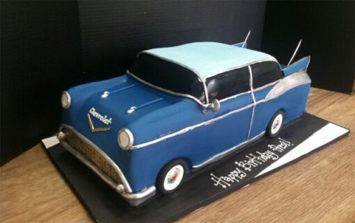 Car Shaped Cake decorated as a racing car with fondant details and colorful decorations.