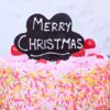 Festive Strawberry Christmas Cake decorated with fresh strawberries and colorful holiday decorations.