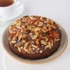 Chocolate Almond Loaf Cake topped with slivered almonds and chocolate drizzle on a white plate