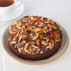 Chocolate Almond Loaf Cake topped with slivered almonds and chocolate drizzle on a white plate