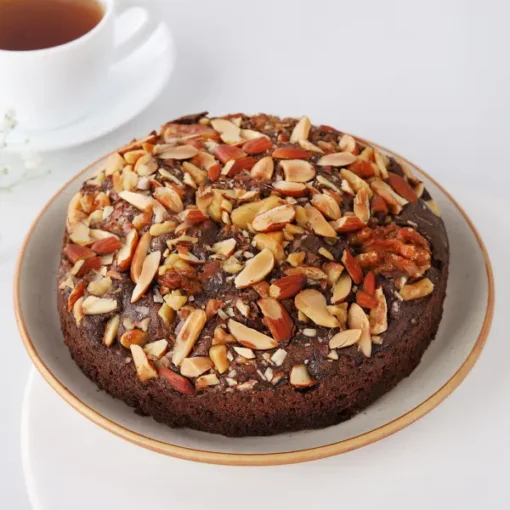 Chocolate Almond Loaf Cake topped with slivered almonds and chocolate drizzle on a white plate