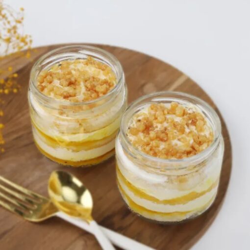 Clear glass jar filled with layered golden cookie crumble, creamy filling, and cake pieces, showcasing Crunchy Golden Cake Jar dessert