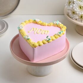Mom’s Pink Heart Delight – pink heart-shaped cake with smooth buttercream frosting and delicate piped decorations.