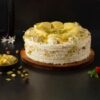 Creamy Rasmalai Delight – cake layered with cardamom-saffron milk, whipped cream, pistachios, and rose petals