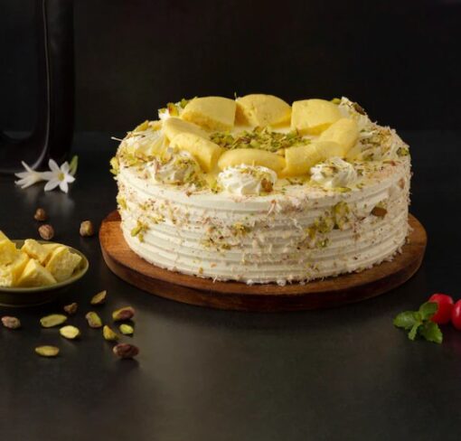 Creamy Rasmalai Delight – cake layered with cardamom-saffron milk, whipped cream, pistachios, and rose petals