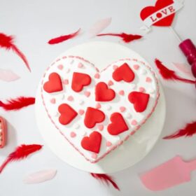 Love’s Radiant Heart Cake – heart-shaped vanilla cake with pink cream drips and fresh roses
