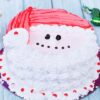 Festive Santa Claus themed cake with red hat and white beard decorations.