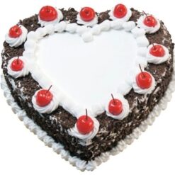 Heart-shaped Black Forest cake decorated with whipped cream, cherries, and chocolate shavings.