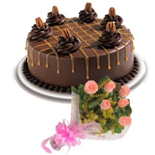 Black Forest cake decorated with pink floral bouquet and cherries.