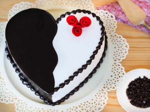 Heart-shaped red velvet cake with elegant decorative accents.