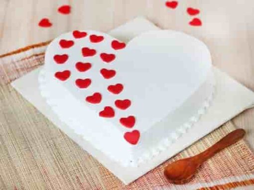 Elegant vanilla cake decorated with delicate edible blossoms and floral accents.