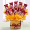 Bouquet featuring KitKat chocolates artfully arranged with fresh flowers.