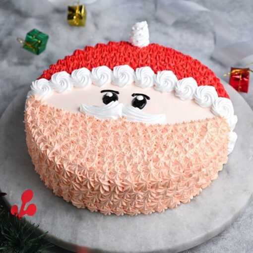 Classic Santa Xmas Cake decorated with Santa Claus icing and festive holiday toppings on a white cake stand