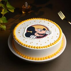 Mickey Mouse themed birthday cake with colorful decorations and character topper