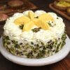 Creamy Pistachio Rasmalai Cake garnished with chopped pistachios and creamy layers