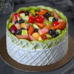 Mixed Fruit Delight Cake topped with fresh colorful fruits and creamy frosting.