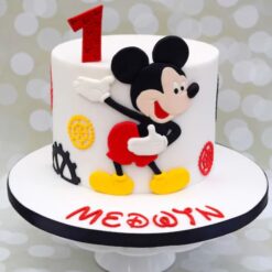Colorful Mickey Mouse Celebration Cake decorated with fondant and edible character toppers.