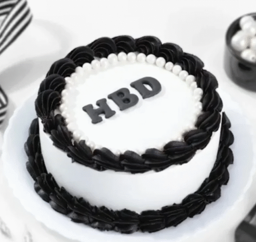 Elegant black and white birthday cake with smooth fondant and decorative accents