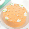 Floral peachy cake decorated with delicate peach-colored flowers and creamy frosting